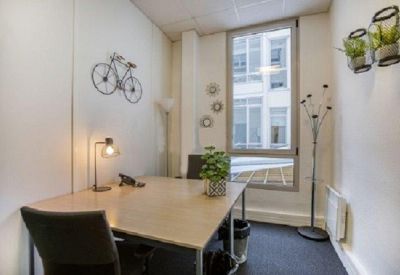 Small office suite featuring a bicycle wall decoration and a bright window.