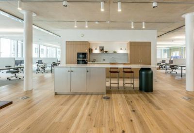 Spacious communal kitchen and breakout area with wooden floors and island seating.