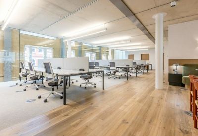 Bright open-plan workspace with white desks and ergonomic chairs.