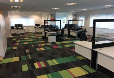 Large open-plan office with colorful carpet tiles.