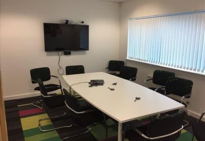 Meeting room with a long table and wall-mounted TV.