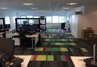 Office area with multiple workstations and colorful flooring.