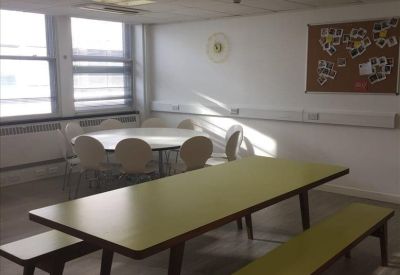 Bright dining area with a round white table and a long lime-green bench table.