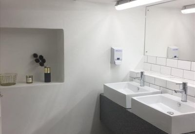 Modern restroom with dual white vessel sinks and subway tile backsplash.