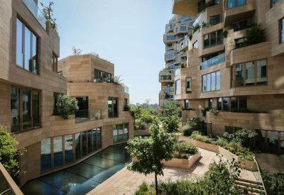 Landscaped outdoor terrace area with stone paths and lush greenery between building tiers.