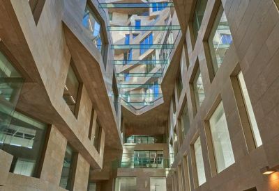 Soaring internal atrium with high ceilings, glass skywalks, and a modern sculpture on the floor.