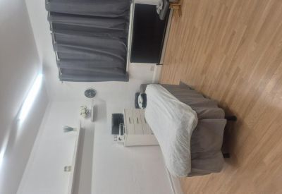 Treatment room featuring a massage bed and wooden flooring.