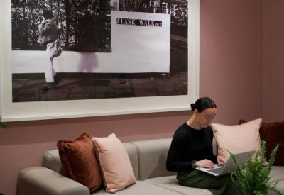 Lounge area with a grey sofa, pink cushions, and a large black and white framed wall art.