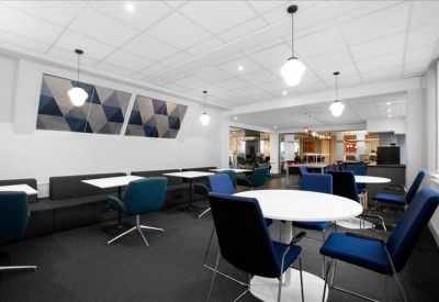 Bright meeting area with round white tables and navy blue chairs.