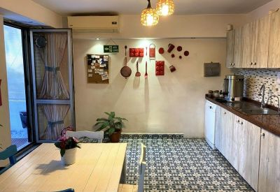 Kitchen and dining area with patterned floor tiles and wooden cabinetry.
