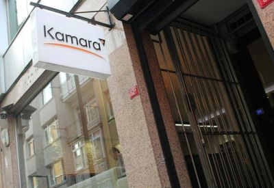 Street-level entrance featuring the white and orange Kamara building signage.