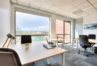 Modern workspace with four desks and bright natural light.