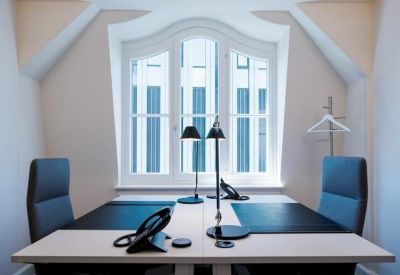 Bright double workstation with modern task lamps and classic arched windows.