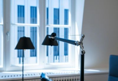 Detailed view of office desk accessories including a black designer task lamp.
