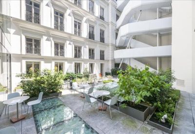Internal courtyard terrace with seating, glass flooring, and lush green plants.