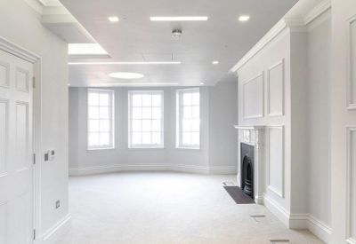 Spacious open-plan office suite with bay windows and recessed ceiling lighting.