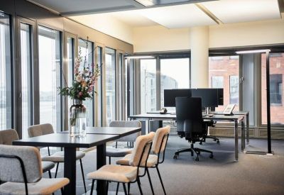 Professional meeting space with a central table, grey chairs, and a decorative floral vase.