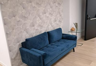 Cozy seating nook with a blue velvet sofa against a patterned feature wall.