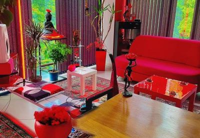 Vibrant coworking lounge with red seating, indoor plants, and floor-to-ceiling windows.