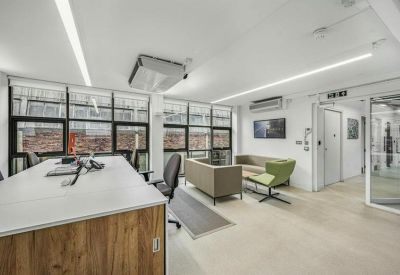 Breakout lounge area with comfortable sofas and a wall-mounted screen.