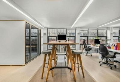 High-top wooden collaboration table with stools in the bright office at 6 Huntsworth Mews.