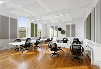 Spacious open-plan workspace with white desks and green acoustic wall panels.