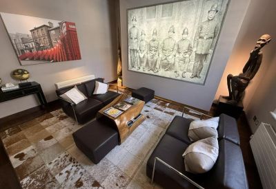Lounge area with leather sofas, animal hide rug, and a large historic wall mural.
