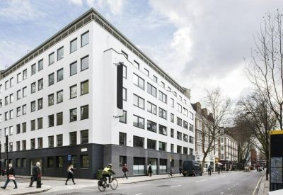 Exterior view of the white corner building at 60 Gray’s Inn Road with dark gray ground floor and street activity.