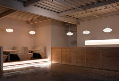 Warmly lit reception desk and seating area with wood paneling and soft lighting.