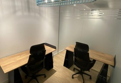 Meeting area with a blue mesh pendant light and sleek wooden desks.