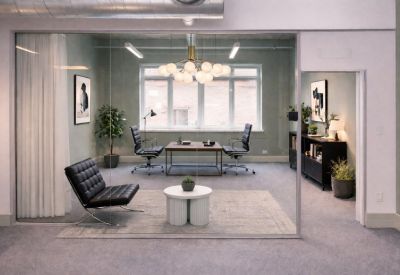 Private office suite with a glass partition, executive desk, and modern leather armchairs.