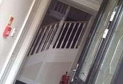 Traditional hallway entrance with white bannister stairs and a dark wood front door.