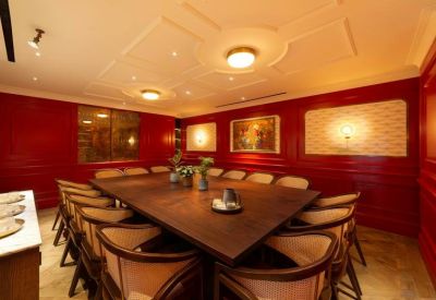 Formal boardroom with red wood-paneled walls and a large dark timber table.