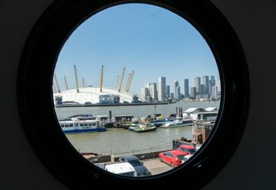 View of the O2 Arena and city skyline framed through a circular porthole window.