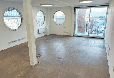 Spacious office interior with multiple porthole-style windows and sliding doors.