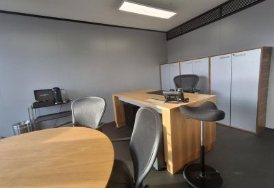 Private office suite with wood-finish desk, storage cabinets, and natural light.