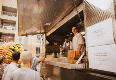 A food truck service area with staff preparing orders for a waiting queue.