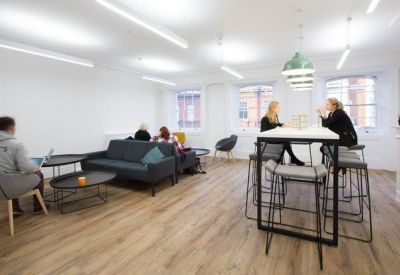 Spacious breakout lounge with a blue sofa, armchairs, and high-top seating.
