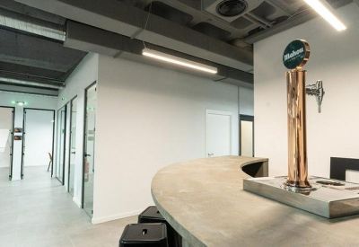 Breakout area featuring a concrete bar counter with a beer tap and hallway access.