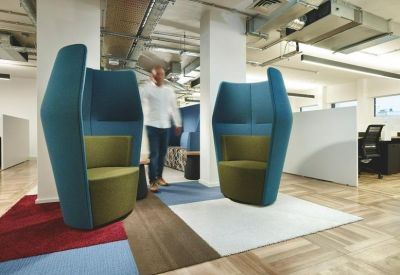 Semi-private high-back acoustic seating pods in an open-plan office space.