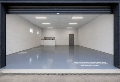 Ground floor unit with grey flooring and a small kitchenette visible through a large loading bay door.