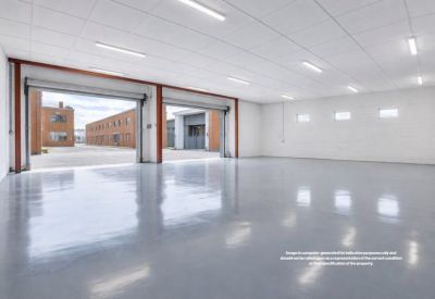 Large empty industrial workspace with twin roller shutter doors opening to an outdoor courtyard.