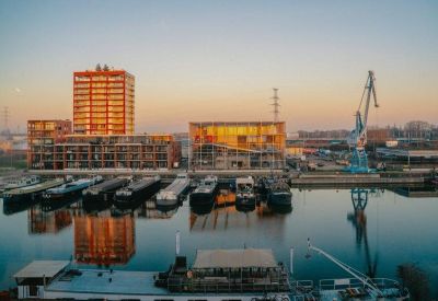 Spacious open-plan office with wooden flooring and abundant natural light.