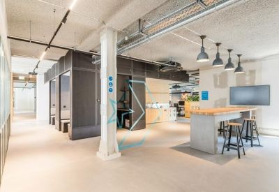 Modern office space with high ceilings and industrial lighting.