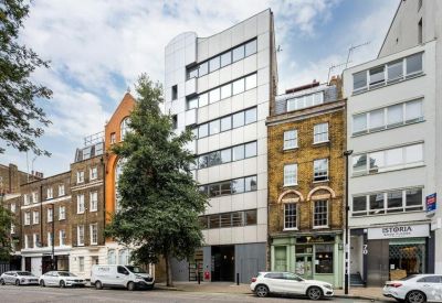 Communal kitchen area with blue sofa and decorative backsplash.