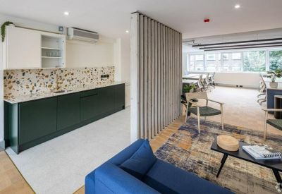 Open-plan workspace with multiple desks and natural light.