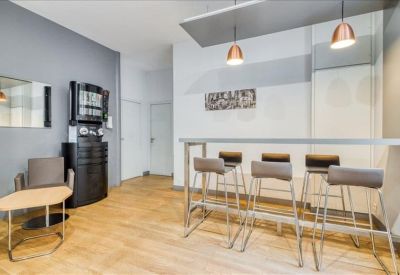 Modern breakout area with high stools, a breakfast bar, and warm copper pendant lighting.