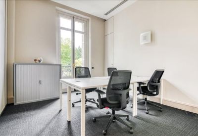 Bright four-person private office with a tall window and grey storage cabinet.