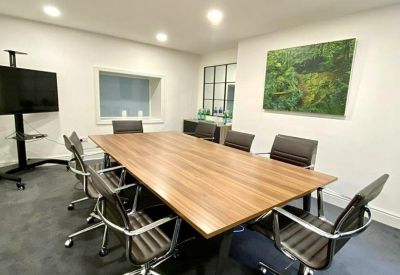 Modern conference room with a large wood-finish table and nature-inspired artwork.