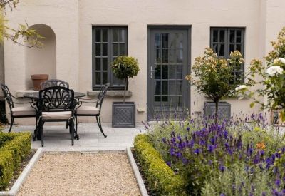 Landscaped outdoor courtyard with seating area and lavender bushes.